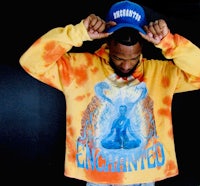 a man wearing a tie dye hoodie with the word enchanted on it