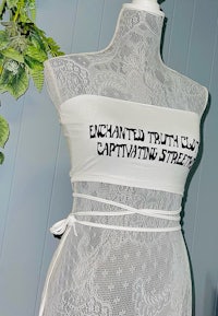 a mannequin wearing a white dress that says enchanted truth captivating truth