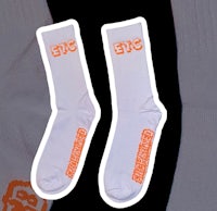 a pair of white socks with orange logos on them