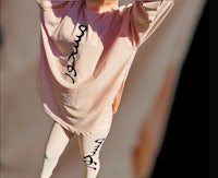 a woman wearing a pink long sleeve shirt and leggings